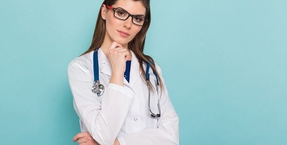 Attractive female doctor in white coat and glasses