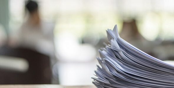 Exam answer sheet or application paper blurry view on table in examination room with blur education background of school university students taking exam test writing answer in seat row with stress